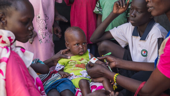 A health worker screening a child for malnutrition in Malakal PoC site, Upper Nile State. 